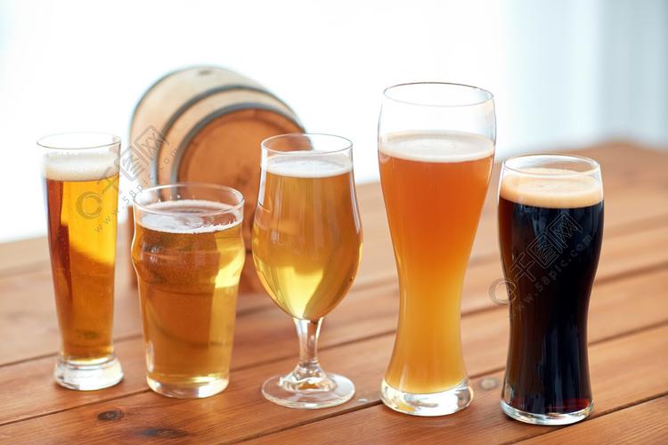啤酒厂,饮料和酒精的概念— —关闭不同的啤酒在眼镜和桌上的桶